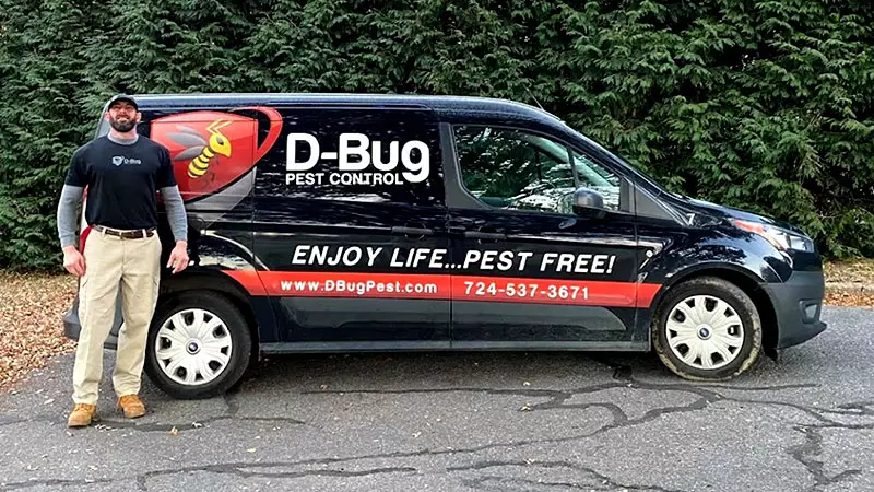 Owner standing in front of D-Bug Pest Control Van