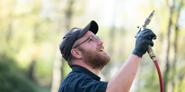 technician spraying home exterior